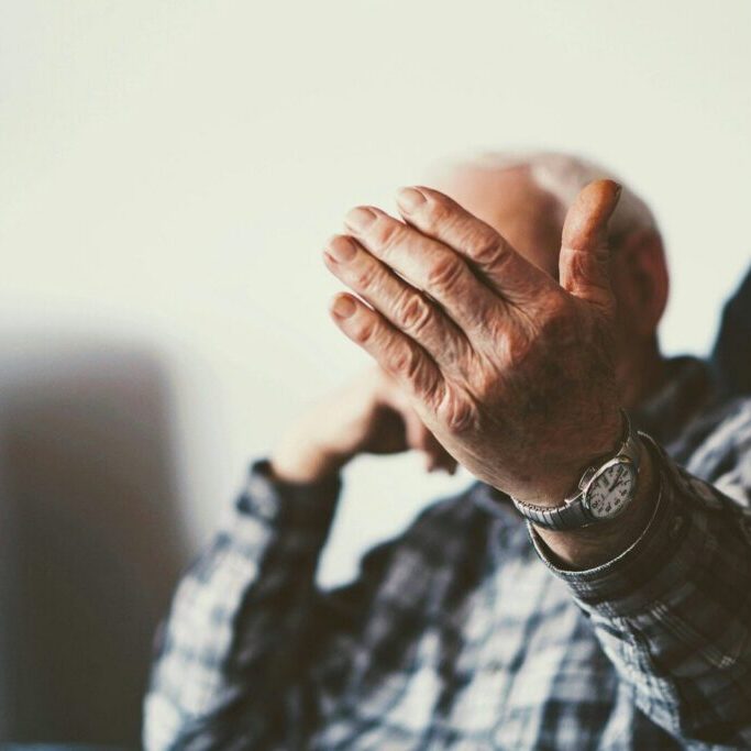 man in blue and white plaid dress shirt wearing silver link bracelet watch